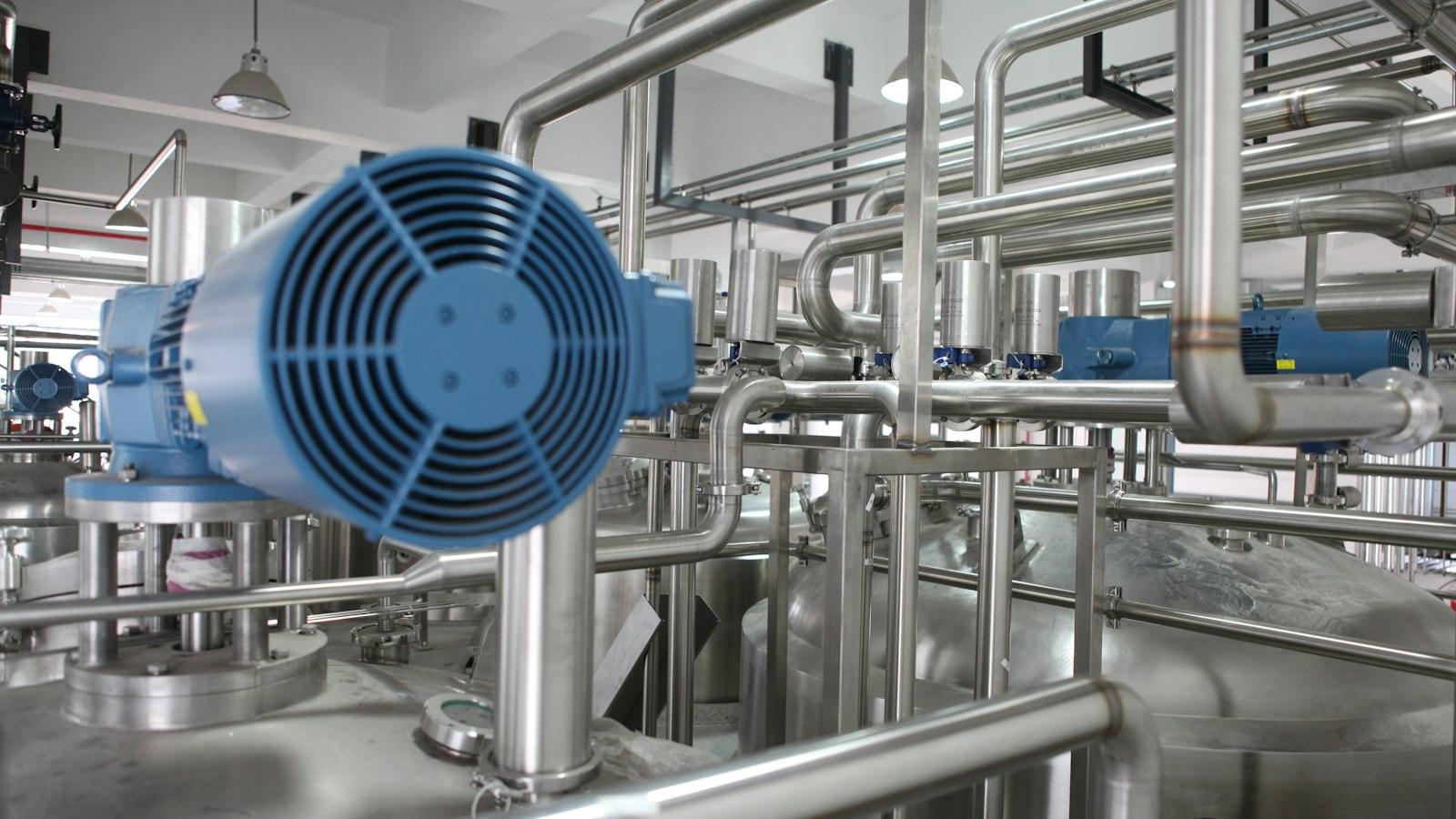 Stainless steel process pipework and a blower motor inside an industrial plant, representing the engineered carbon capture covered by Verra methodology VM0049