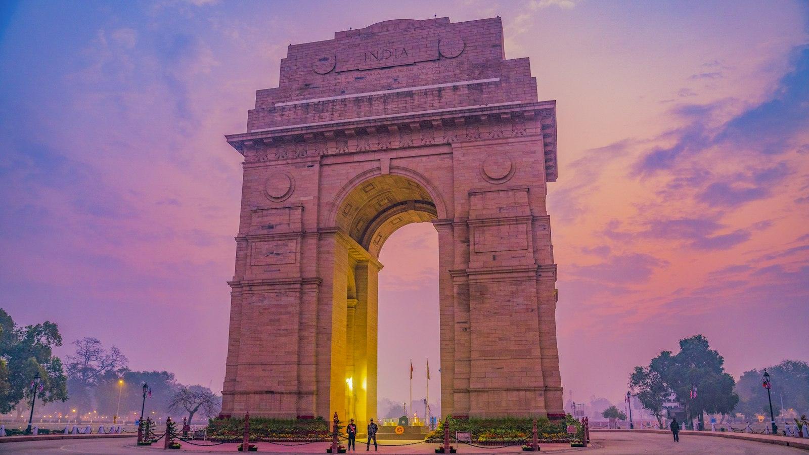 India Gate in New Delhi at dusk under a violet sky; New Delhi is home to the regulator and exchanges that run carbon credit certificate trading